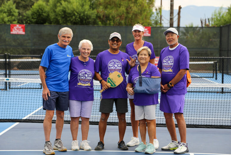 Family and friends of Medina gather in front of pickleball net