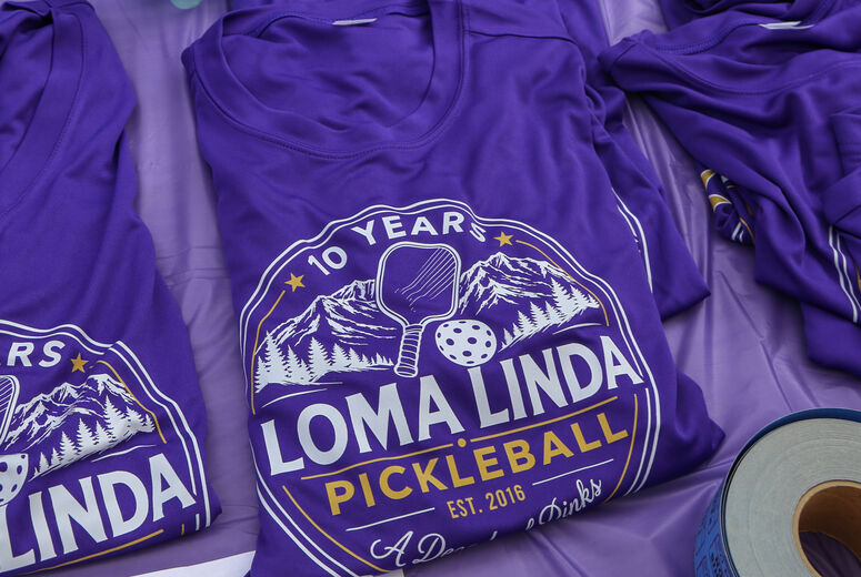"Loma Linda Pickleball" shirts laid out on table