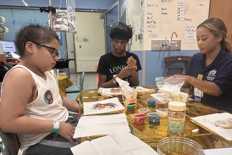 pediatric cancer patients decorate cookies with volunteer