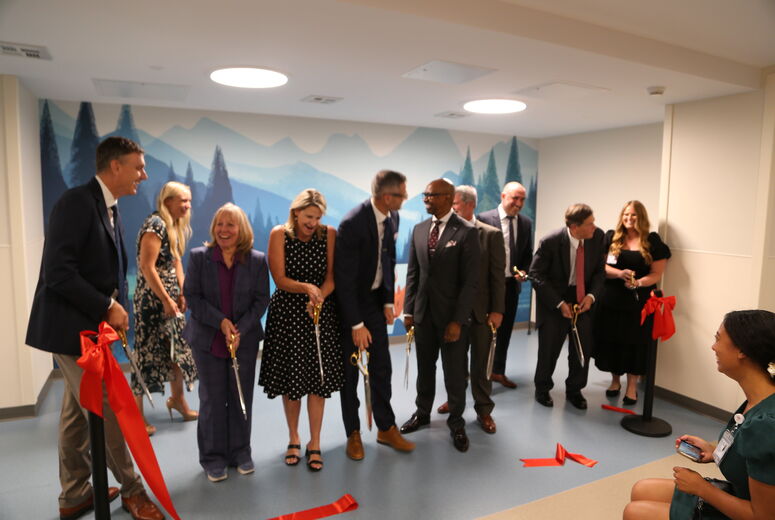 leaders smile and interact after cutting ribbon