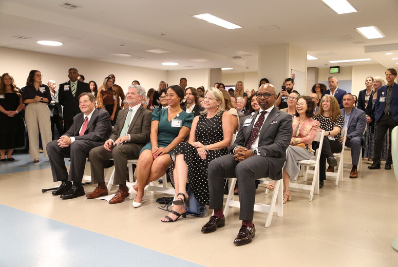 seated audience listens to ceremony speakers