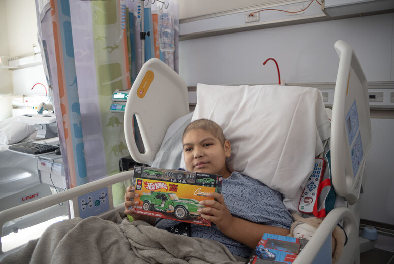 sick patient poses with gifted toy