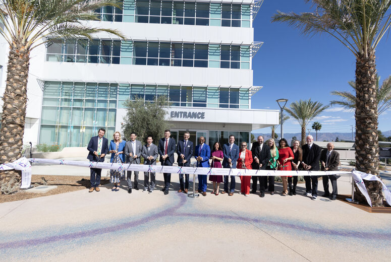 LLUH and government officials pose with ribbon in front of specialty clinics building