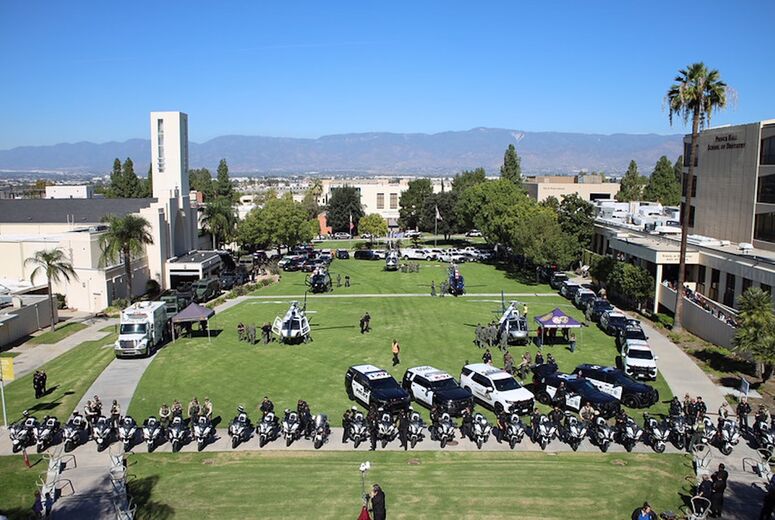 overhead image of police vehicles and helicopters on lawn