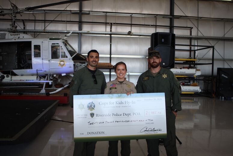 officers hold large donation check