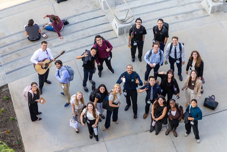 aerial image of a group of students looking up at the camera, smiling, during welcome back bash