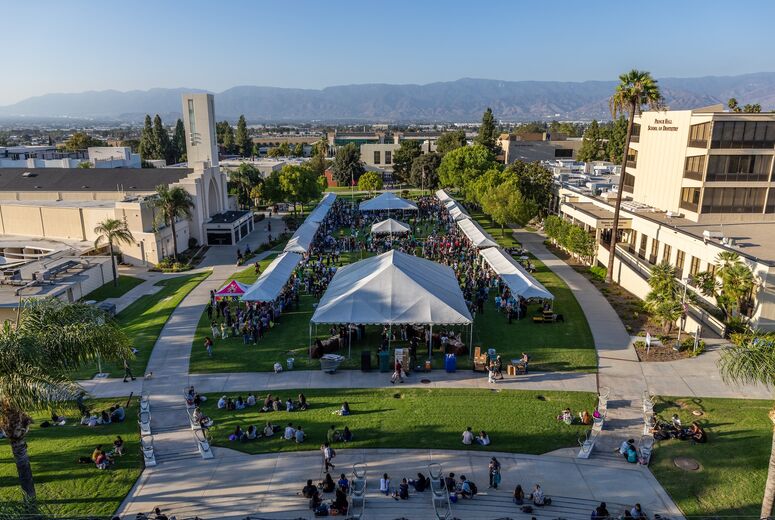 aerial view of welcome back bash showing crowd of people and tents on the campus lawn