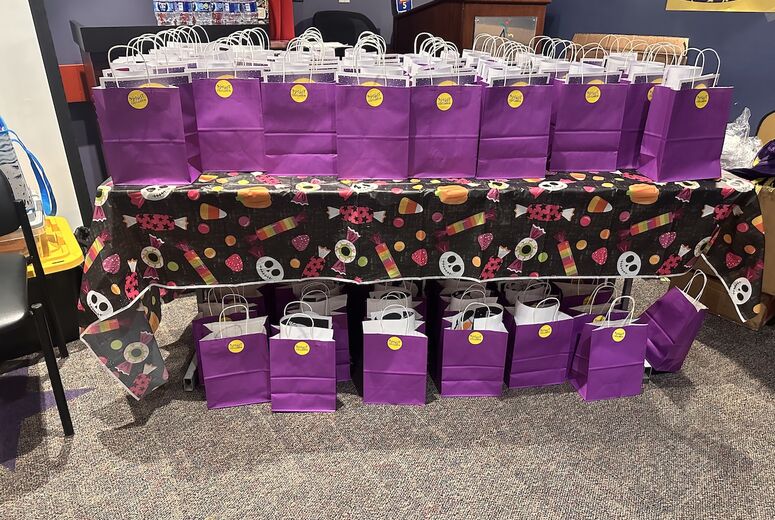 table full of purple gift bags