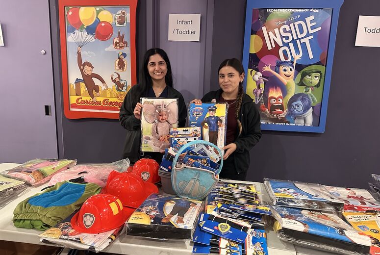 hospital staff holds up costumes for photo