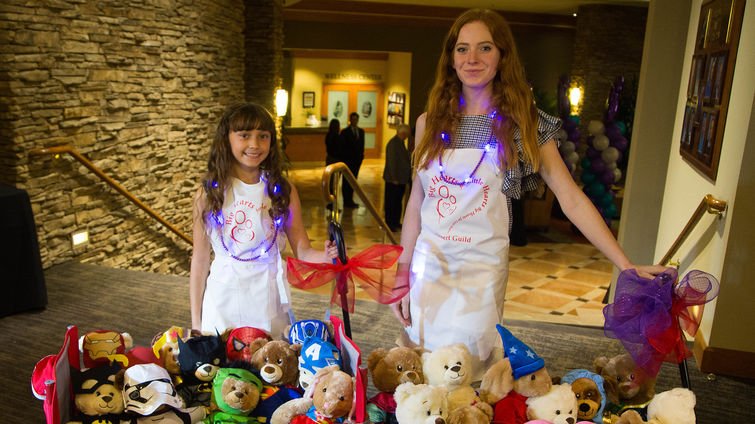 Girls, Guys & Giving 2019 two young girls standing with red wagons full of teddybears