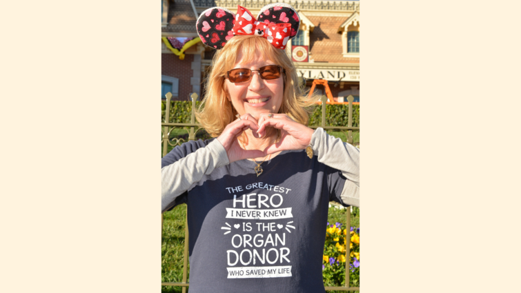 Julie Hutchinson makes a heart with her hands while wearing an organ donor appreciation shirt