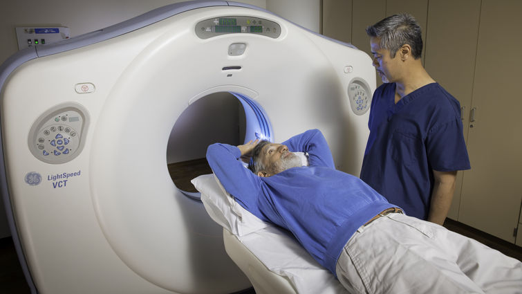 Man lying on bed before going into CT machine