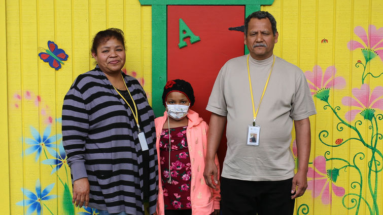 hispanic female pediatric patient poses for photo with her mother and father