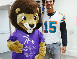 NFL Miami Dolphins linebacker Jaelan Phillips takes photos with Luke the Lion during his visit to Loma Linda University Children’s Hospital