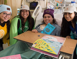 Loma Linda University Children’s Hospital patients gifted beanies from Love Your Melon Women in hospital smiling for photo