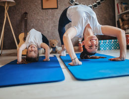 mom and daughter do yoga at home