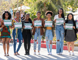Nine students hold up signs stating where they matched for their residency