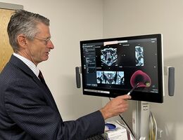 A doctor reviews a scan of a patient's prostate