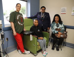 Family sits smiling with doctor in office