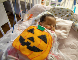 female infant with felt pumpkin costume