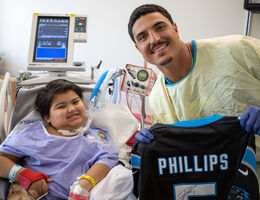 Phillips poses with a young patient