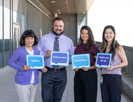 Infection Disease doctors holding up blue and purple signs that say Fighting Antimicrobial Resistance Takes All of Us