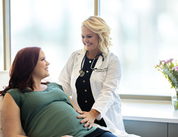 Dr. Courtney Martin stands bedside with pregnant patient