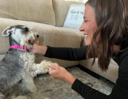 Woman playing with small dog smiling