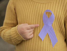 An epilepsy awareness ribbon pinned to child's sweater
