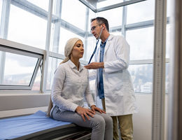 Doctor listening to the heartbeat of a cancer patient on a consultation - stock photo