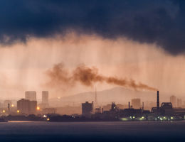 Dramatic sunrise and rain over industrial area - stock photo