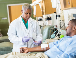 Senior phlebotomist checking on patient before taking blood sample