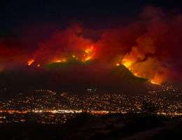 A wildfire burns the mountains endangering houses