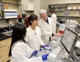 Dr. Arlin Blood conducts research with two students
