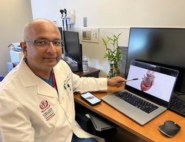 Kamal M. Kotak, MD, a cardiac electrophysiologist at Loma Linda University International Heart Institute, points to an interactive rendering of a human heart.