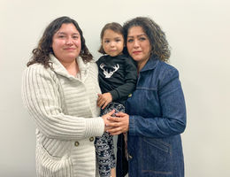 Estefania Morales (left), Giselle Morales (middle), Isabel Graciano (right) hispanic young mom embraces her mom and young daughter while standing together