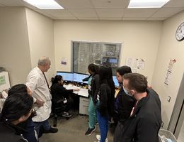 Dr. Bannout, in a white coatm with a group of students and residents during a teaching session about seizures 