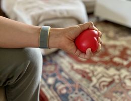 Person squeezing a heart-shaped stress ball