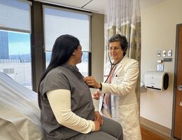 A doctor examines a patient's heart using a stethoscope. 