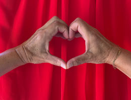 Woman makes heart shape with hands