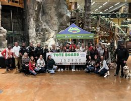 Volunteers and participants gather for a check presentation