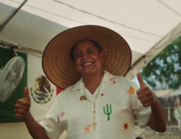 Patient jose Espinoza wearing a hat is facing the camera giving two thumbs up 