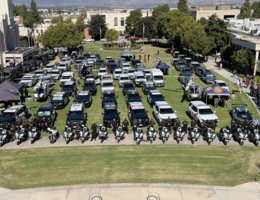 Aerial view of the Loma Linda University campus north lawn filled with rows of police vehicles, motorcycles, and officers from various Southern California law enforcement agencies during the 24th Annual Cops for Kids Fly-In event.