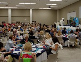 Wide shot of event space filled with guests sitting at their tables and officers lined up by the kitchen