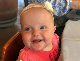 Baby sitting in high chair giggling