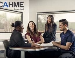 three college students and a professor sitting around a table conversing.