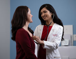 Dr. Parwani checks patient's heart beat with a stethoscope