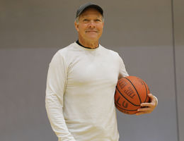 Enrique Gonzalez smiling, holding a basketball