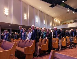 individuals standing in prayer in a chapel