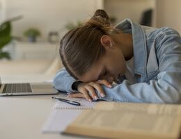 Exhausted Young Student Girl Sleeping on Desk While Studying at Home
